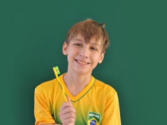 Junge im Fußballtrikot mit Zahnbürste