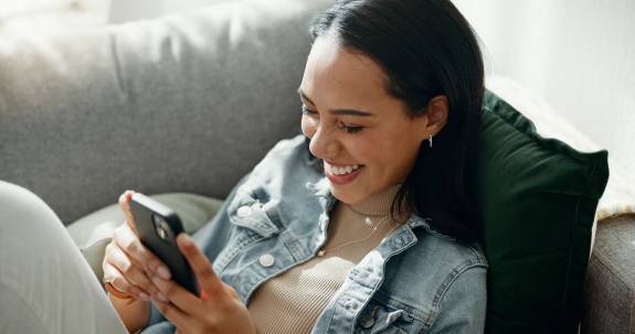 Frau lacht über etwas am Telefon