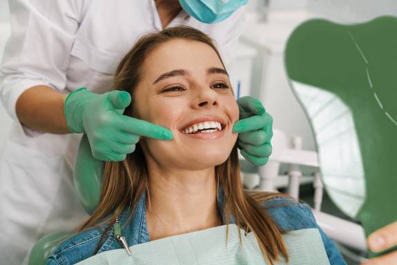 Zahnärztin zeigt auf Gebiss der Patientin